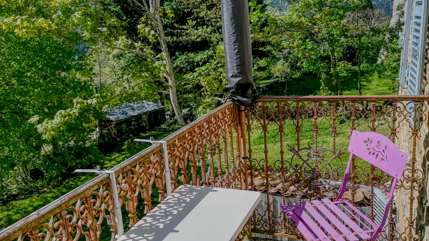 Balcon en fer forgé de Maison Marthe donnant sur le jardin privé arboré.
